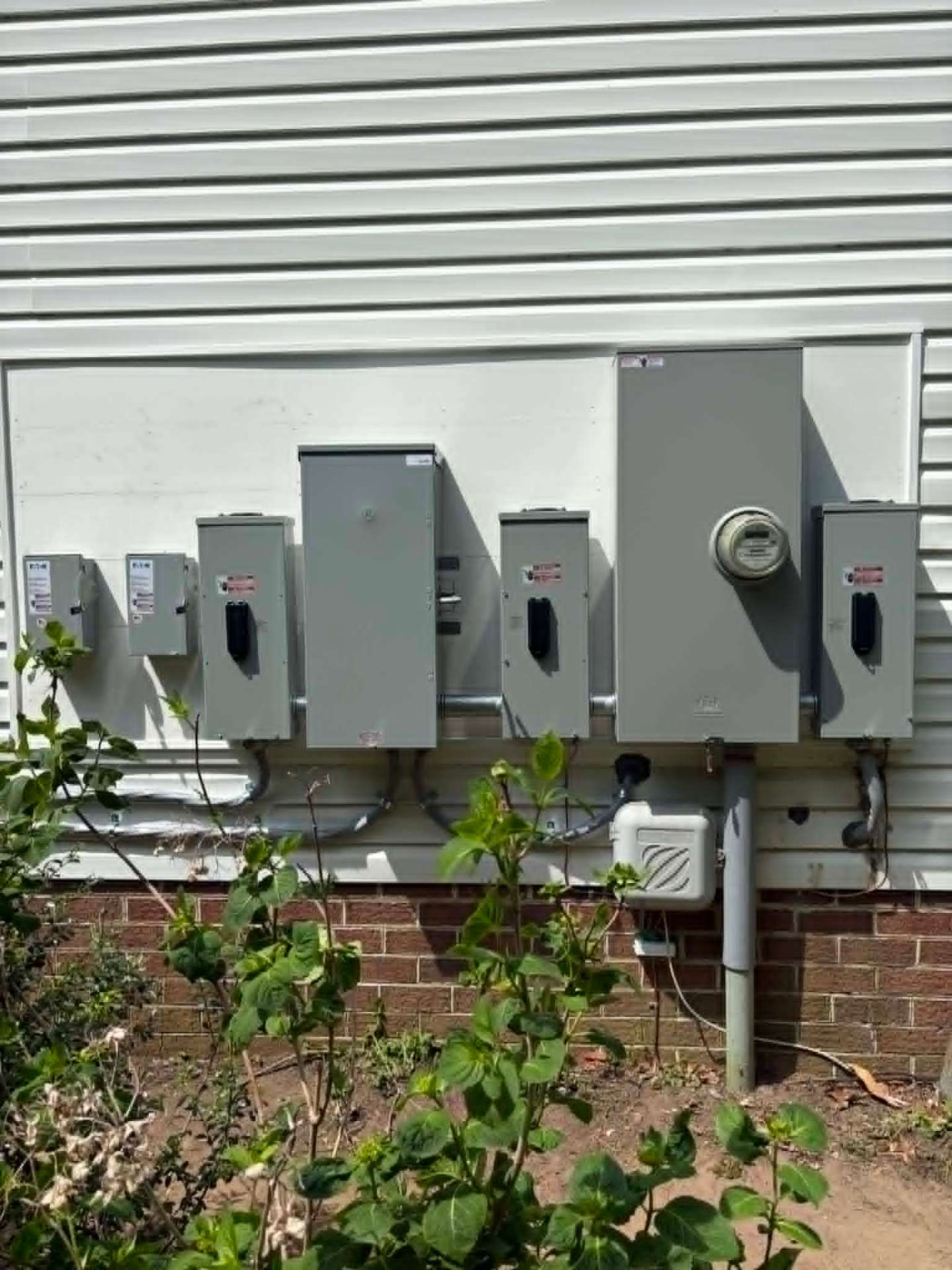 Multi-unit meter bank with panels and disconnects installed by Mikk Services